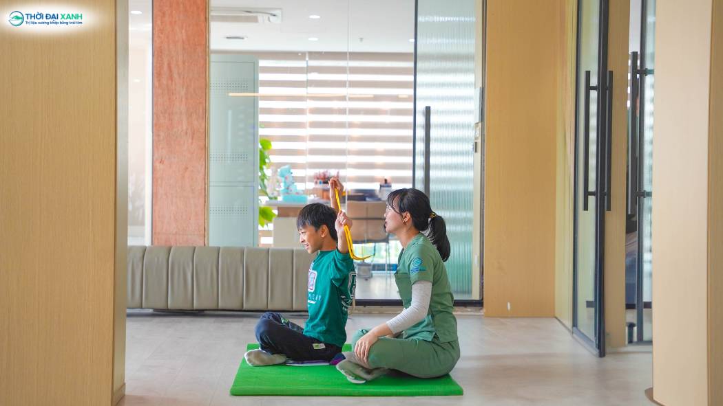 Kỹ thuật viên hướng dẫn bài tập phục hồi chức năng cho khách hàng tại Thời Đại Xanh