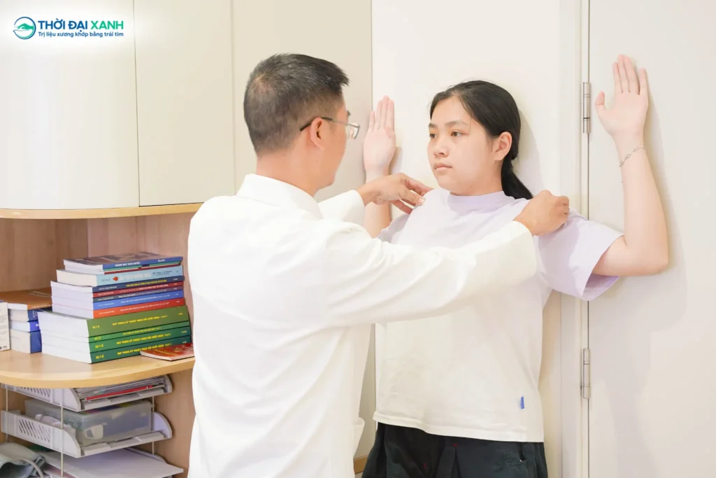 BS.CKI Trần Quang Chí kiểm tra độ cân bằng vai nhằm phát hiện sớm các dấu hiệu cong vẹo cột sống học đường ở trẻ.