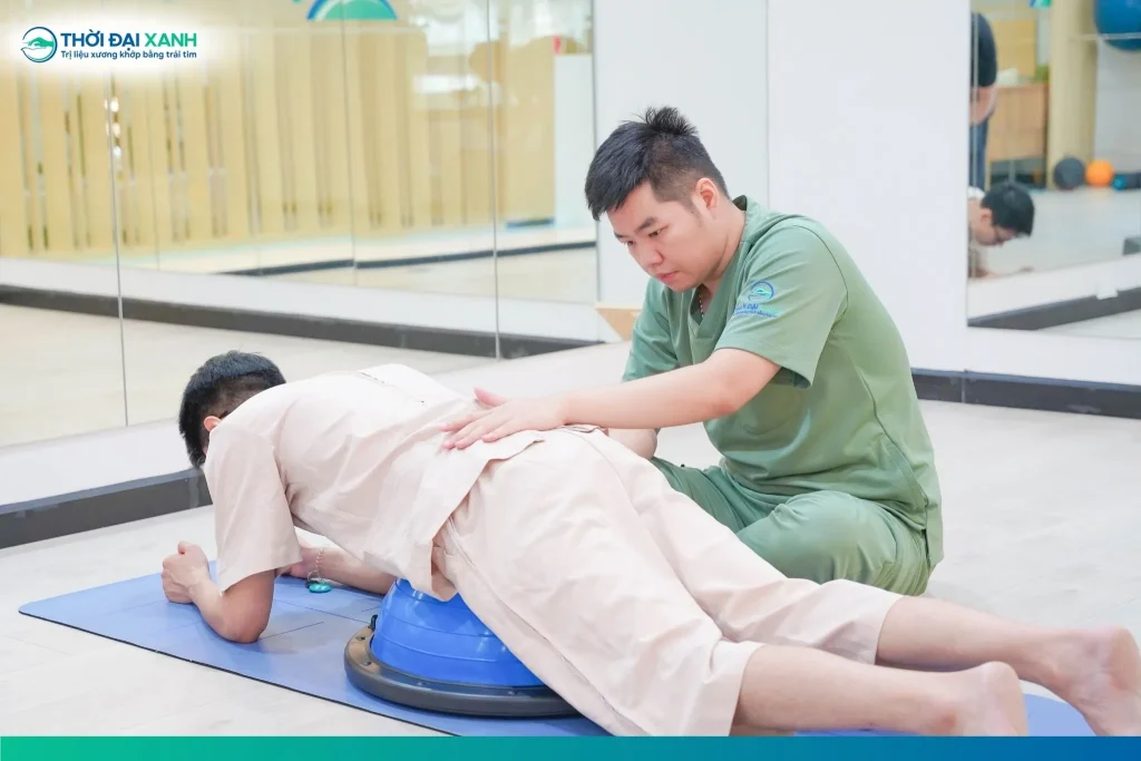 Đội ngũ Kỹ thuật viên khoa Phục hồi chức năng Thời Đại Xanh hướng dẫn khách hàng thực hiện bài tập hỗ trợ trong phục hồi tình trạng trượt đốt sống.